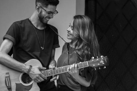 Noivo tocando violão e cantando para noiva fotografia preto e branco'