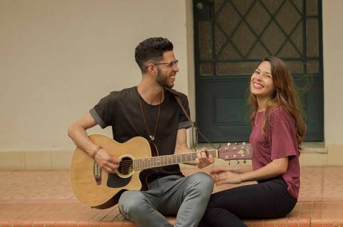 noivos tocando violão com um sorrisão lindo no rosto'