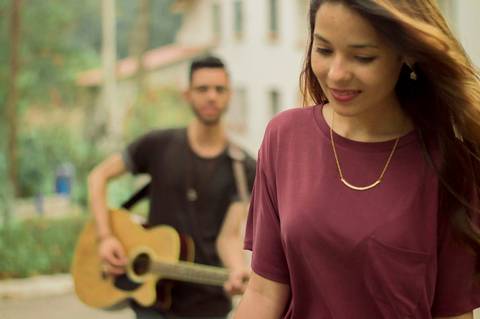 noiva caminhando e noivo cantando e tocando violão'