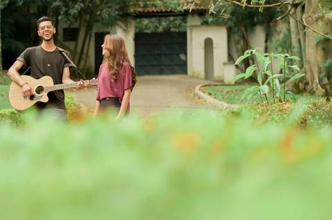noivo cantando e caminhando tocando violão ensaio pré casamento'