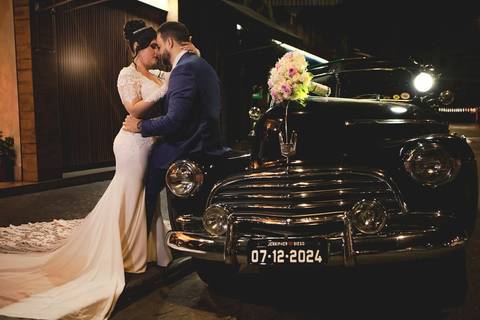 As melhores ideias e inspirações criativas de fotos de casamento registradas por fotógrafos profissionais de eventos da empresa Criativus Foto e Vídeo. Fotos dos noivos em um carro antigo no estilo clássico na cor preta'