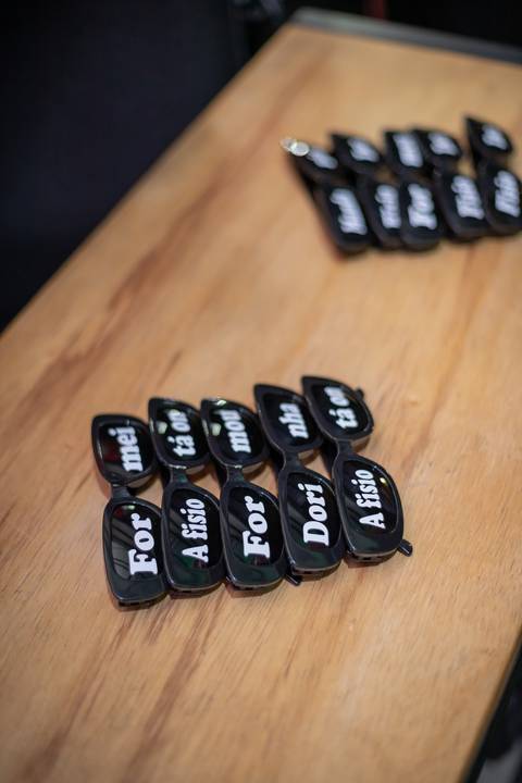 ALt text: óculos decorativos com frases escritas nas lentes: formei, a fisio tá on, Formou, Dorinha'