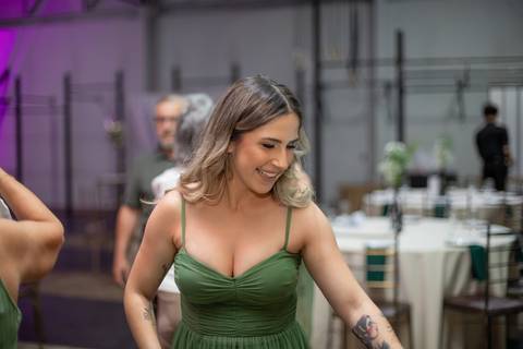Alt text: formanda sorrindo de vestido verde longo e cabelos loiros soltos'