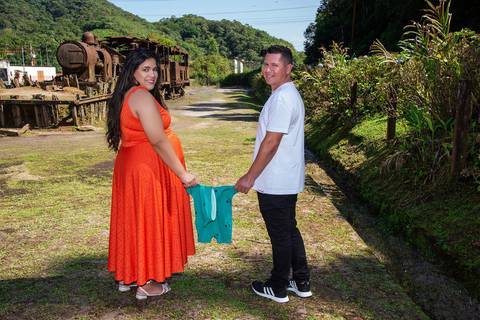 Ensaio Gestante Paranapiacaba SP Pais Segurando Body Pelas Mangas Passeando e Olhando Para Trás'