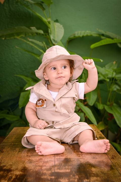 Fotografia do Aniversariante Segurando Seu Chapéu Com Sua Roupa de Explorador no Rancho Abor Aricanduva SP. Foto por Priscila Felix fotógrafa de família, ensaios e casamentos.'