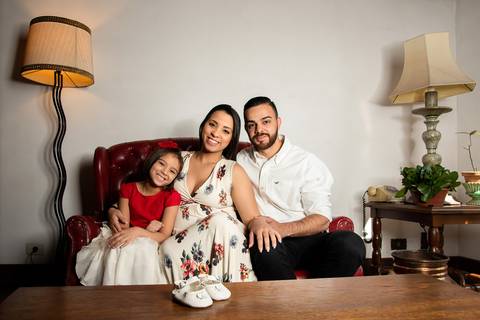 Pai, Mãe, Filha e Sapatinho da Bebê Sentados No Sofá No Estúdio Jardim Guedala em São Paulo, Foto Feita Pela Priscila Felix Fotógrafa de Família, Casamento e Ensaios '