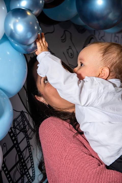 Foto do Aniversariantes Beliscando as Bexigas no Colo da Tia Na Vila Andrade - SP. Foto por Priscila Felix, fotógrafa de família, ensaios, eventos e casamentos.'
