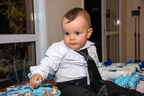 Foto do Aniversariante Sentado na Mesa de Doces Na Vila Andrade - SP. Foto por Priscila Felix, fotógrafa de família, ensaios, eventos e casamentos.'