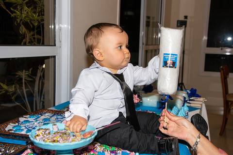 Foto do Aniversariantes Na Mesa de Doces Pegando Um Algodão Doce Com Seu Nome Giovanni Na Vila Andrade - SP. Foto por Priscila Felix, fotógrafa de família, ensaios, eventos e casamentos.'