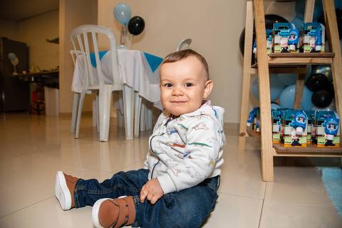 Foto do Aniversariante Sentado no Chão Olhando para a Câmera Na Vila Andrade - SP. Foto por Priscila Felix, fotógrafa de família, ensaios, eventos e casamentos.'