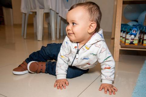 Foto do Aniversariante Engatinhando Olhando Para Trás Na Vila Andrade - SP. Foto por Priscila Felix, fotógrafa de família, ensaios, eventos e casamentos.'