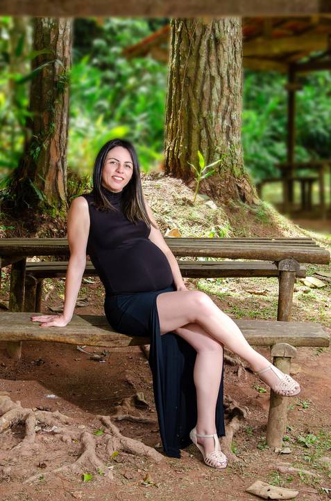 Foto da Mãe de Vestido Preto Sentada No Banco de Madeira de Pernas Cruzadas No Núcleo Engordador Na Cantareira em São Paulo, Foto Feita Pela Priscila Felix Fotógrafa de Família, Casamento e Ensaios '
