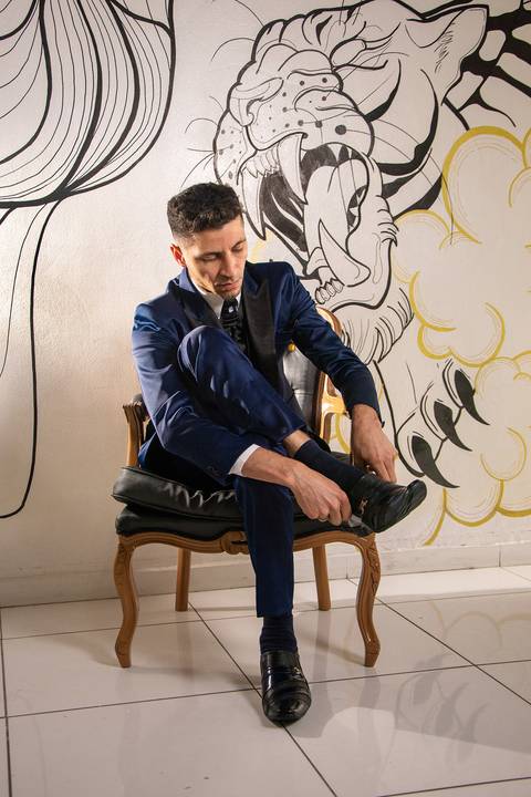 Fotografia do Noivo Colocando os Sapatos na Barbearia Be King em Guarulhos SP Feita por Priscila Felix Fotógrafa de Casamentos, Ensaios e Família'