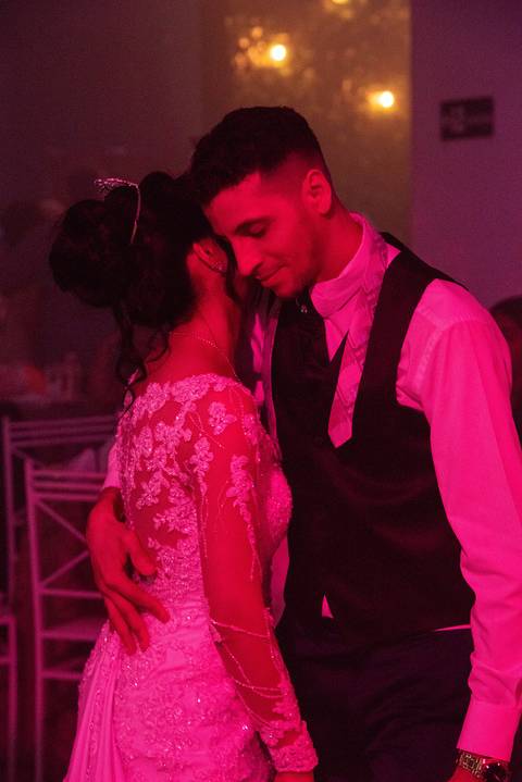 Fotografia dos Noivos Dançando Tingidos de Rosa Pela Luz do DJ No Buffet Europa em Guarulhos SP Feita por Priscila Felix Fotógrafa de Casamentos, Ensaios e Família'