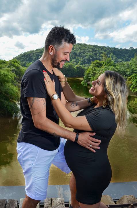 Foto do Casal Sorrindo Um de Frente para o Outro Em Cima da Linha do Trem com o Rio Passando Embaixo em Guararema - SP, Foto Feita Pela Priscila Felix Fotógrafa de Família, Casamento e Ensaios '