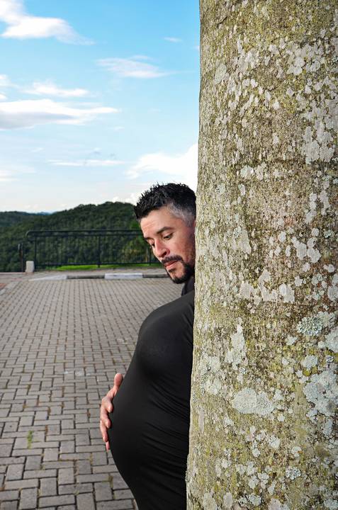 Foto do Pai Atrás de uma Árvore Segurando a Barriga da Mãe Como se Fosse a Dele No Mirante de Guararema - SP, Foto Feita Pela Priscila Felix Fotógrafa de Família, Casamento e Ensaios '