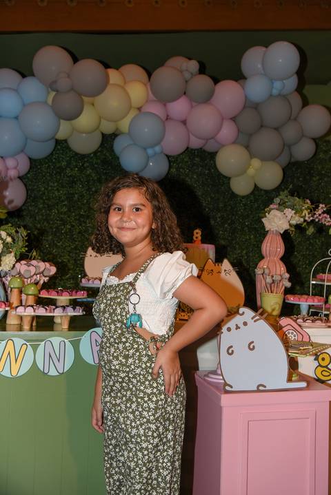 Foto da Aniversariante Em Frente à Mesa do Bolo Com a Mão Na Cintura e um Belo Sorriso No Buffet Pindorama Na Vila Conceição - SP, Foto Feita Pela Priscila Felix Fotógrafa de Família, Casamento e Ensaios '