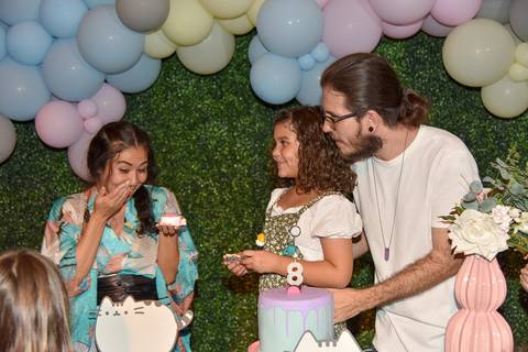 Foto da Aniversariante Com Seus Pais A Mãe Com Um Doce Na Mão Fingindo Surpresa No Buffet Pindorama Na Vila Conceição - SP, Foto Feita Pela Priscila Felix Fotógrafa de Família, Casamento e Ensaios '