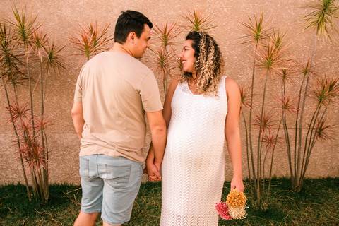 Foto do Casal de Mãos Dadas No Jardim Do Apartamento, a Mãe Segura um Buquê de Rosas em Itaquera - SP, Foto Feita Pela Priscila Felix Fotógrafa de Família, Casamento e Ensaios '