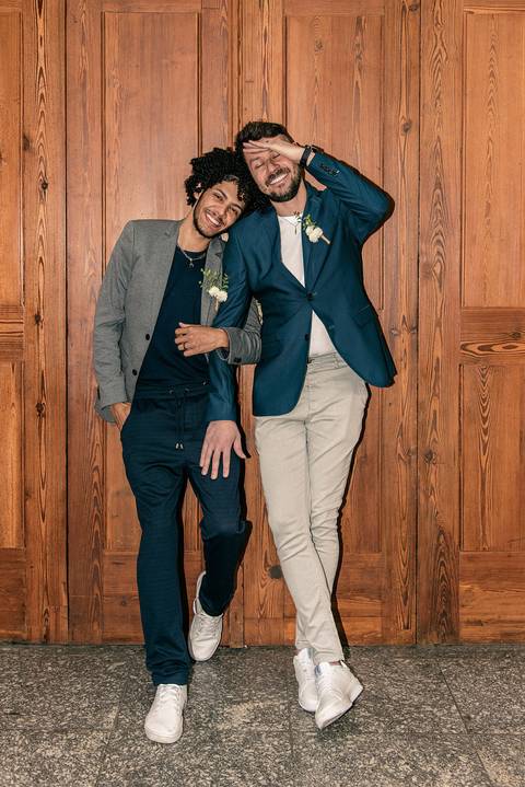 Foto do Casal Em Frente à Uma Porta de Madeira Enorme De Braços Cruzados Sorrindo Na Estação da Luz em São Paulo - SP, Foto Feita Pela Priscila Felix Fotógrafa de Família, Casamento e Ensaios '