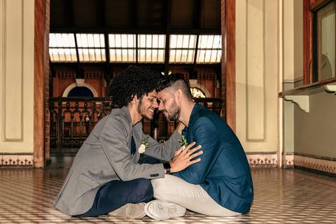 Foto do Casal Sentado No Chão Um de Frente Pro Outro de Testa Colada e Olhos Fechados Na Estação da Luz em São Paulo - SP, Foto Feita Pela Priscila Felix Fotógrafa de Família, Casamento e Ensaios '