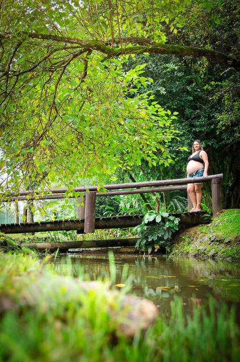 Foto da Mãe de Perfil No Topo da Ponde de Madeira e Seu Reflexo nas Águas do Rio No Bosque Maia em Guarulhos - SP, Foto Feita Pela Priscila Felix Fotógrafa de Família, Casamento e Ensaios '