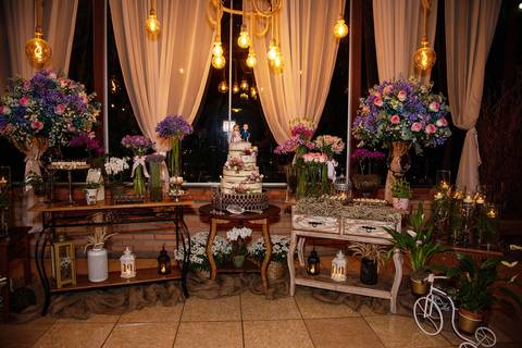 Fotografia da Mesa do Bolo Com Iluminação Amarela e Mesinhas Vitorianas Em Mairiporã SP Feita por Priscila Felix Fotógrafa de Casamentos, Ensaios e Família'