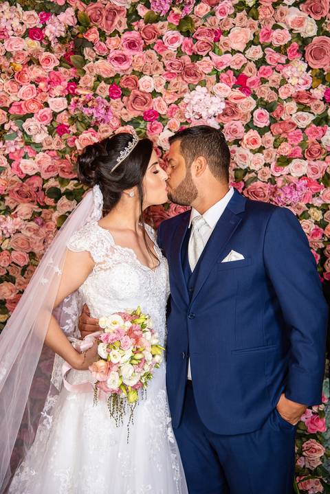 Fotografia dos Noivos Se Beijando Com Fundo de Flores Rosas Naturais Em Mairiporã SP Feita por Priscila Felix Fotógrafa de Casamentos, Ensaios e Família'