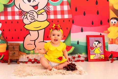 Fotografia da Bebê Pegando o Cacho de Uva e Sorrindo no Estúdio Com Cenário da Magali da Turma da Monica em SP Feita por Priscila Felix Fotógrafa de Casamentos, Ensaios e Família'