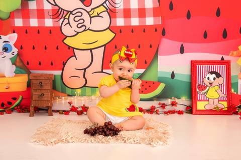 Fotografia da Bebê Comendo Um Pedaço de Melancia no Estúdio Com Cenário da Magali da Turma da Monica em SP Feita por Priscila Felix Fotógrafa de Casamentos, Ensaios e Família'