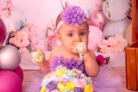 Fotografia da Bebê Toda Suja de Bolo Comendo Mais Um Pedaço no Estúdio Com Cenário Rosa Com Bexigas Personalizadas em SP Feita por Priscila Felix Fotógrafa de Casamentos, Ensaios e Família'