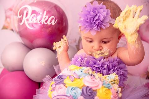 Fotografia da Bebê Batendo as Mãos No Bolo no Estúdio Com Cenário Rosa Com Bexigas Personalizadas em SP Feita por Priscila Felix Fotógrafa de Casamentos, Ensaios e Família'