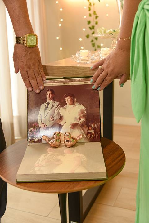 Fotografia dos Noivos No Álbum de Casamento Aberto e Somente As Mãos Deles Atuais Aparecendo no Tatuapé SP Feita por Priscila Felix Fotógrafa de Casamentos, Ensaios e Família'