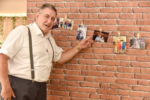 Fotografia do Noivo Mostrando Uma Foto no Mural De Fotos de Suas Viagens no Tatuapé SP Feita por Priscila Felix Fotógrafa de Casamentos, Ensaios e Família'