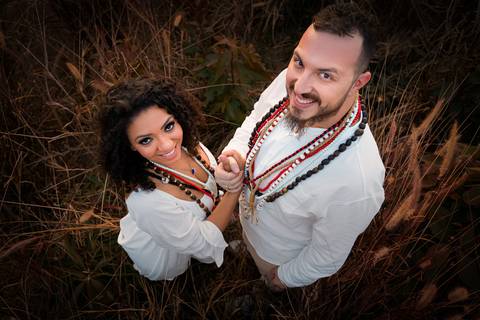 Foto dos Noivos Sorrindo de Mãos Dadas Com Visão de Cima Em Meio ao Trigo a Noite No Sítio Essência do Campo Ensaio Casal Pre Wedding Em Holambra SP, feita pela Priscila Felix, fotógrafa de casamentos, ensaios e eventos'