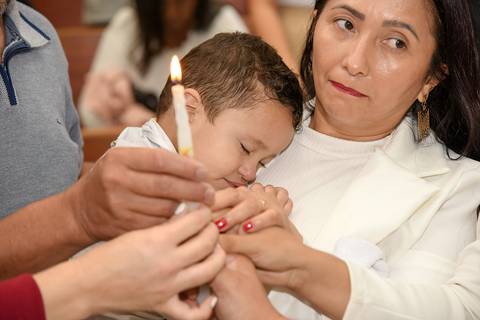 Fotografia do Batizado No Colo da Mãe Segurando a Vela Batismal Na Igreja São José em São Paulo, SP Feita por Priscila Felix Fotógrafa de Casamentos, Ensaios e Família'