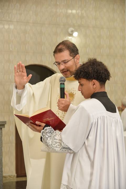 Fotografia do Padre Lendo as Escrituras Segurado Pelo Coroinha Na Igreja São José em São Paulo, SP Feita por Priscila Felix Fotógrafa de Casamentos, Ensaios e Família'