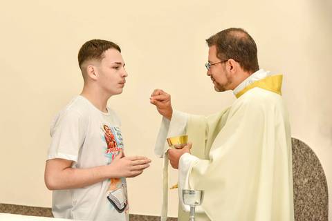 Fotografia do Crismado Recebendo a Hóstia Na Igreja São José em São Paulo, SP Feita por Priscila Felix Fotógrafa de Casamentos, Ensaios e Família'