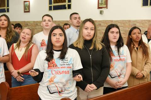 Fotografia da Crismada De Mãos Abertas Em Direção Ao Altar Orando Na Igreja São José em São Paulo, SP Feita por Priscila Felix Fotógrafa de Casamentos, Ensaios e Família'