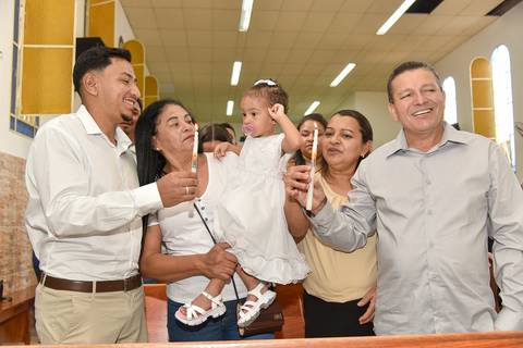 Fotografia dos Padrinhos Com as Velas do Batismo Acesas Sorrindo Na Igreja São José em São Paulo, SP Feita por Priscila Felix Fotógrafa de Casamentos, Ensaios e Família'