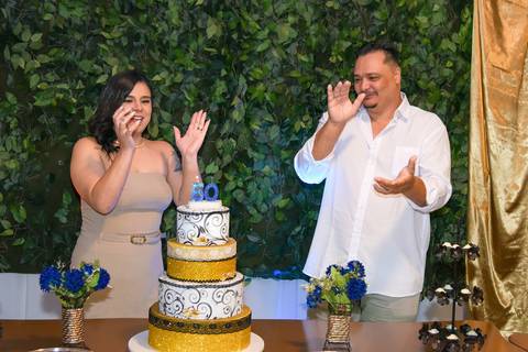 Foto do Aniversariante Com A Esposa Cantando Parabéns e Batendo Palmas Na Mesa do Bolo No Buffet Em São Paulo - SP, Foto Feita Pela Priscila Felix Fotógrafa de Família, Casamento e Ensaios '
