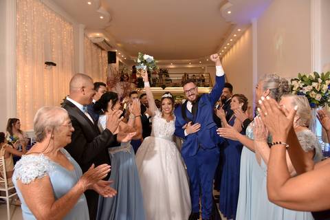 Fotografia dos Noivos Saindo Comemorando Passando Num Corredor Feito Pelos Pais e Padrinhos em Mansão Pimenta Nativa Salão de Festas no Tatuapé - SP Feita por Priscila Felix Fotógrafa de Casamentos, Ensaios e Família'