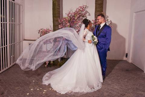 Fotografia dos Noivos Se Olhando e o Véu da Noiva Esvoaçando No Jardim em Mansão Pimenta Nativa Salão de Festas no Tatuapé - SP Feita por Priscila Felix Fotógrafa de Casamentos, Ensaios e Família'