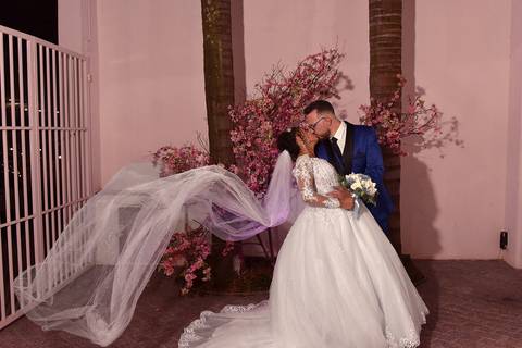 Fotografia dos Noivos Se Beijando e o Véu da Noiva Esvoaçando No Jardim em Mansão Pimenta Nativa Salão de Festas no Tatuapé - SP Feita por Priscila Felix Fotógrafa de Casamentos, Ensaios e Família'