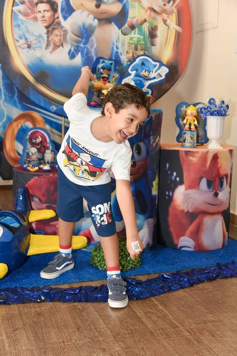 Foto do Aniversariante Em Frente a Decoração do Sonic Rindo Fazendo a Pose de Corrida do Sonic No Buffet Festas & Cia Na Mooca - SP, Foto Feita Pela Priscila Felix Fotógrafa de Família, Casamentos e Ensaios '