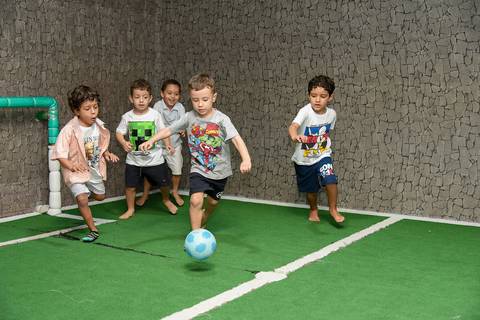 Foto do Aniversariante Correndo Atrás da Bola Com Os Coleguinhas No Campo de Futebol Do Buffet Festas & Cia Na Mooca - SP, Foto Feita Pela Priscila Felix Fotógrafa de Família, Casamentos e Ensaios '