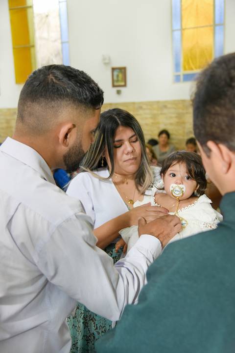 Fotografia do Padre Passando o Óleo No Peito Da Batizada Na Igreja São José em São Paulo, SP Feita por Priscila Felix Fotógrafa de Casamentos, Ensaios e Família'