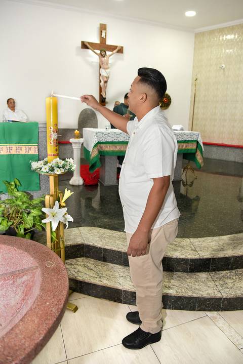 Fotografia do Padrinho Da Lavínia Acendendo A Vela Do Batismo Na Igreja São José em São Paulo, SP Feita por Priscila Felix Fotógrafa de Casamentos, Ensaios e Família'