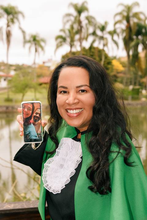 Foto da Formanda Segurando o Celular Mostrando a Filha e o Genro Ao Vivo No Parque do Pau D´Alho Em Guararema - SP, Foto Feita Pela Priscila Felix, Fotógrafa de Família, Casamento e Ensaios '
