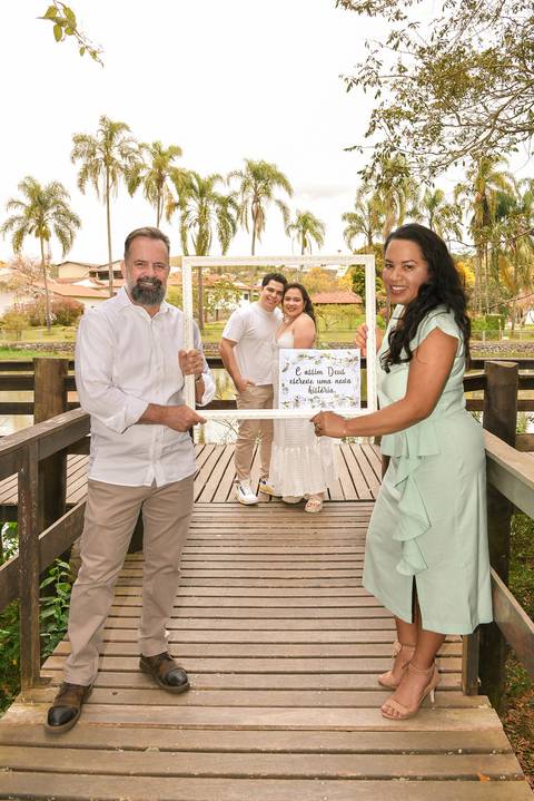 Foto da Formanda Segurando Uma Moldura Junto Com O Marido E, Ao Fundo, Dentro da Moldura A Filha Com O Namorado No Parque do Pau D´Alho Em Guararema - SP, Foto Feita Pela Priscila Felix, Fotógrafa de Família, Casamento e Ensaios '